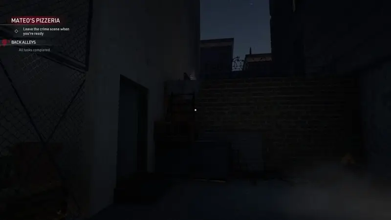 Back alleyway with a brick wall and a step ladder piled on top of a pallet.