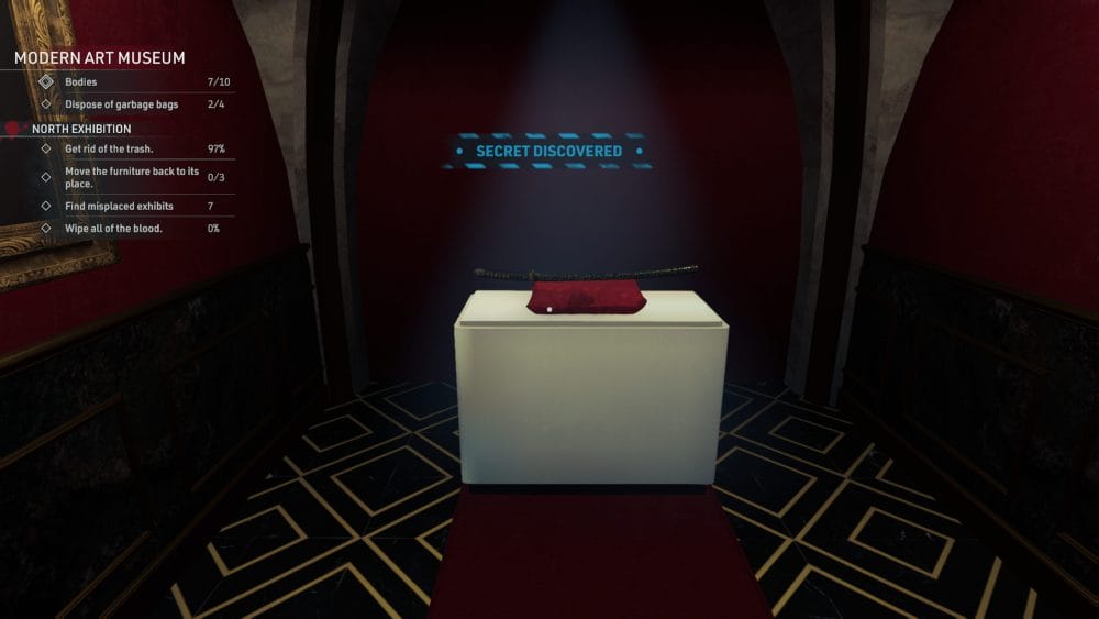 A black katana rests upon a red pillow on a display.
